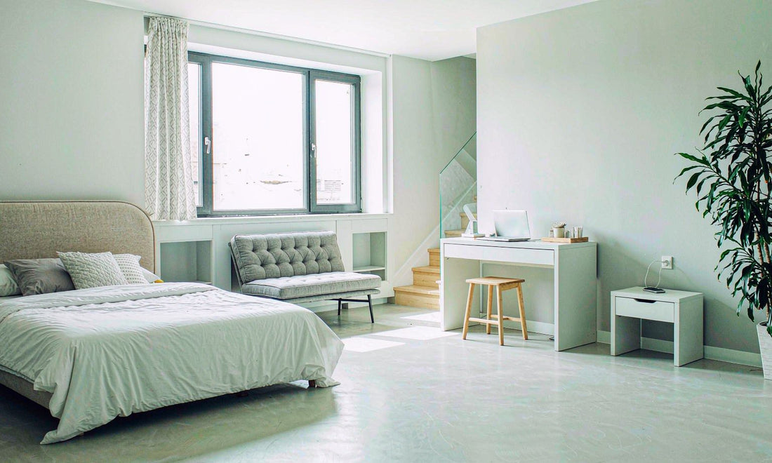 Bright airy bedroom interior with dimmed lamp and phone across the room
